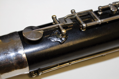 On this bassoon a crack was glued back in place with epoxy. It is not pretty, but it secures the post and holds the key on.